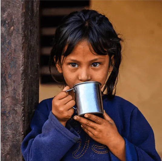 young girl drinking out of metal jug